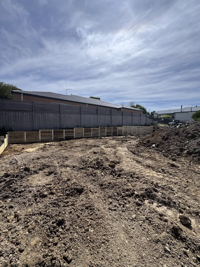 Dark sleeper retaining wall on a large commercial site cut
